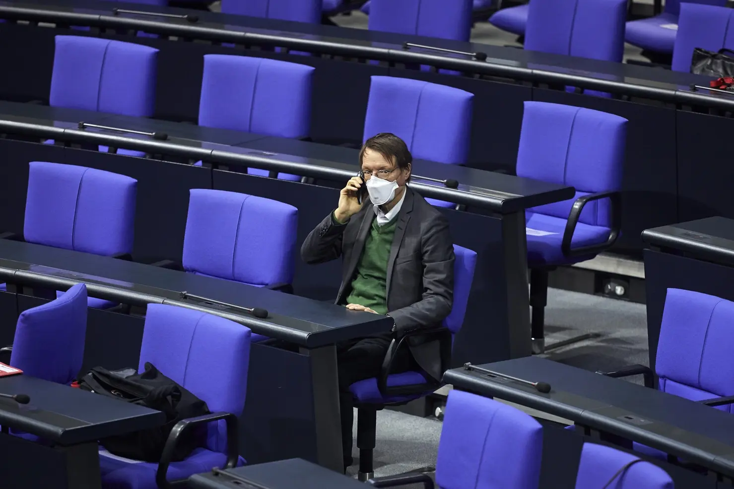 Karl Lauterbach sitzt allein mit Maske im Plenum des Deutschen Bundestages.