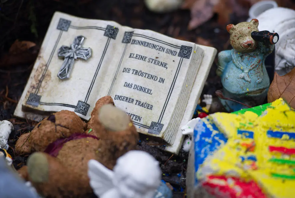 Ein Gebetbuch aus Stein und Spielzeugfiguren auf dem Friedhof