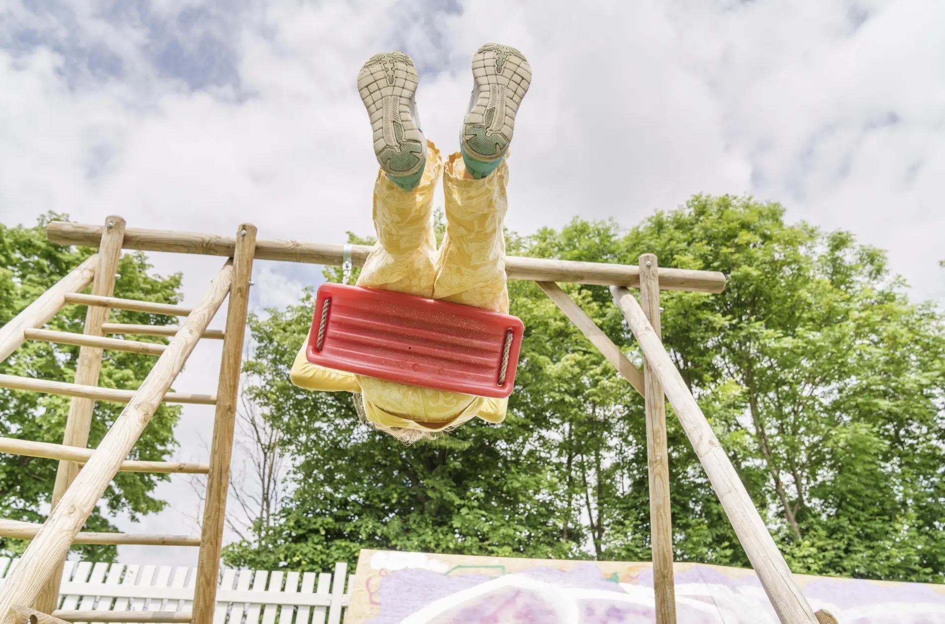 Ein Mädchen schaukelt auf dem Spielplatz.