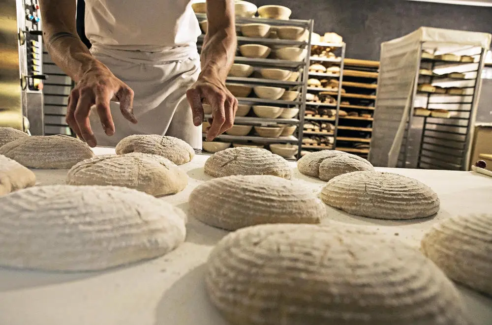 Brot wird hergerichtet, bevor es in den Ofen geschoben wird.