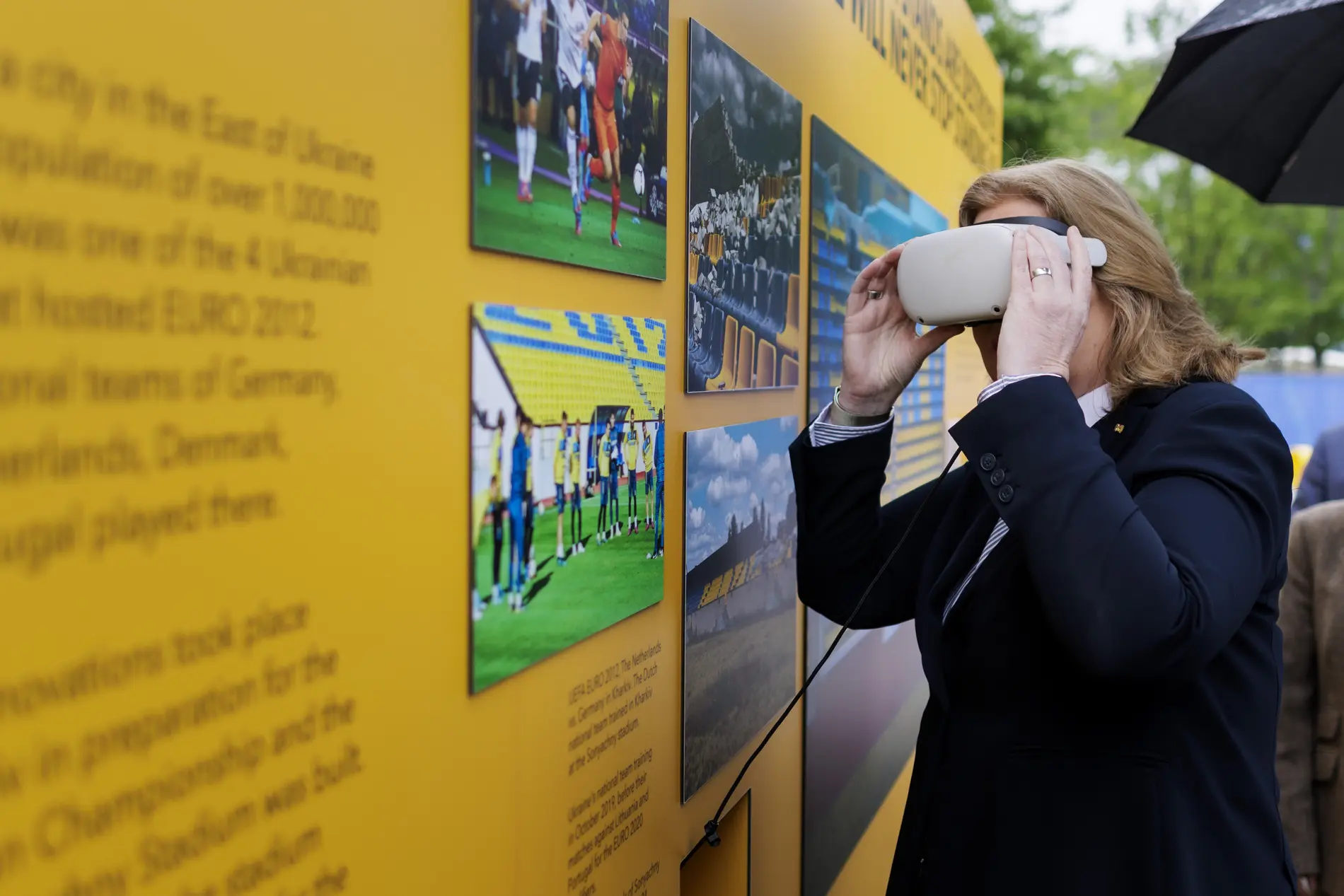 Bärbel Bas mit einer VR-Brille vor einer gelben Info-Wand