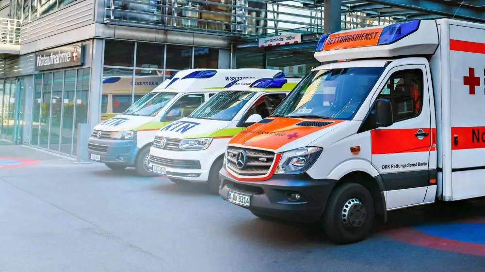 Drei nebeneinander geparkte Krankenwagen.