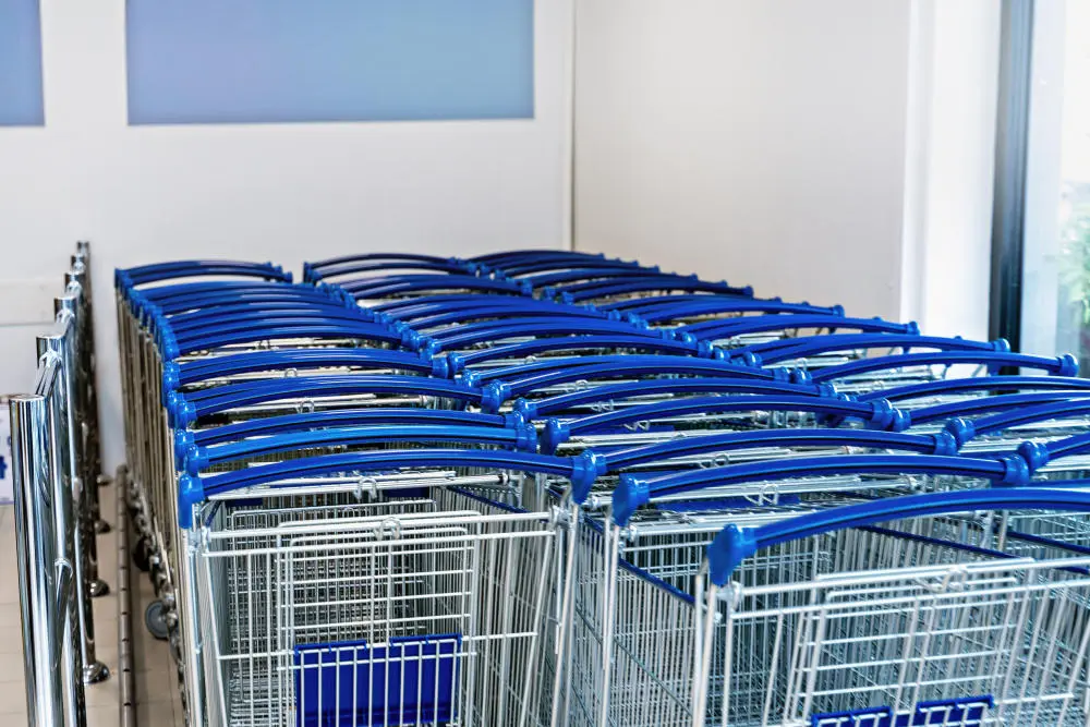 Blaue Einkaufswagen in einer Box für Einkaufswagen vor einem Supermarkt