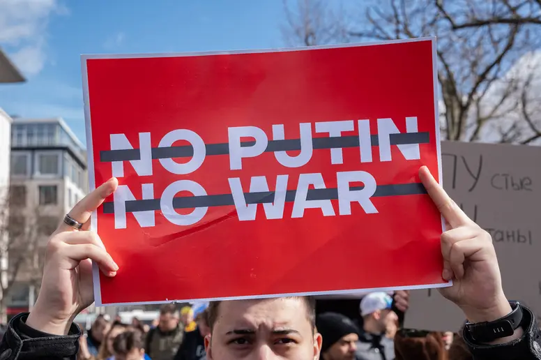 Demonstrant hält ein Schild mit "No Putin, No War" hoch.