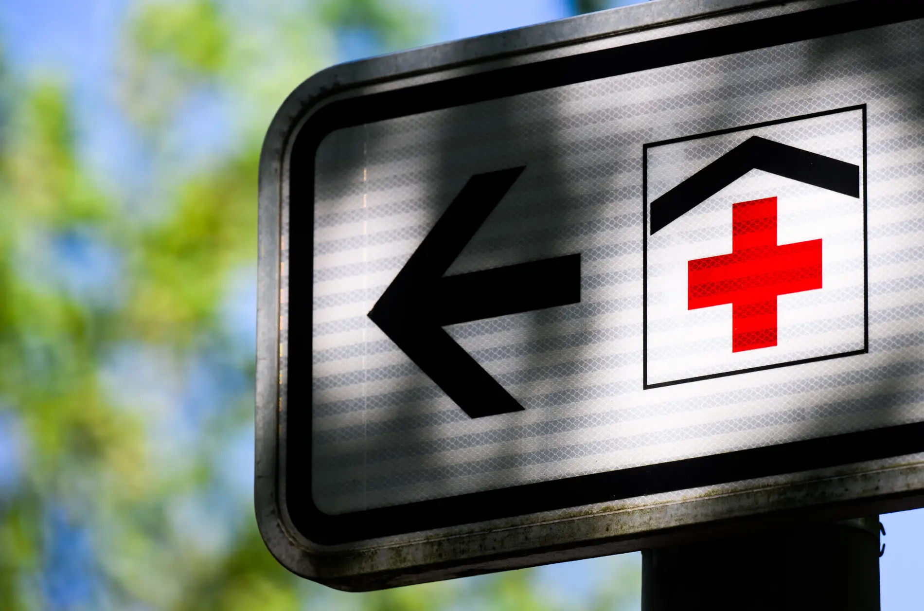 Ein weißes Schild mit dem Symbol für ein Krankenhaus