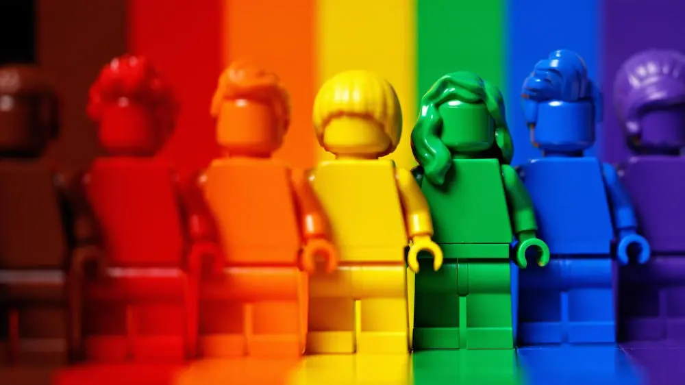 Lego-Figuren in Regenbogenfarben nebeneinander aufgestellt