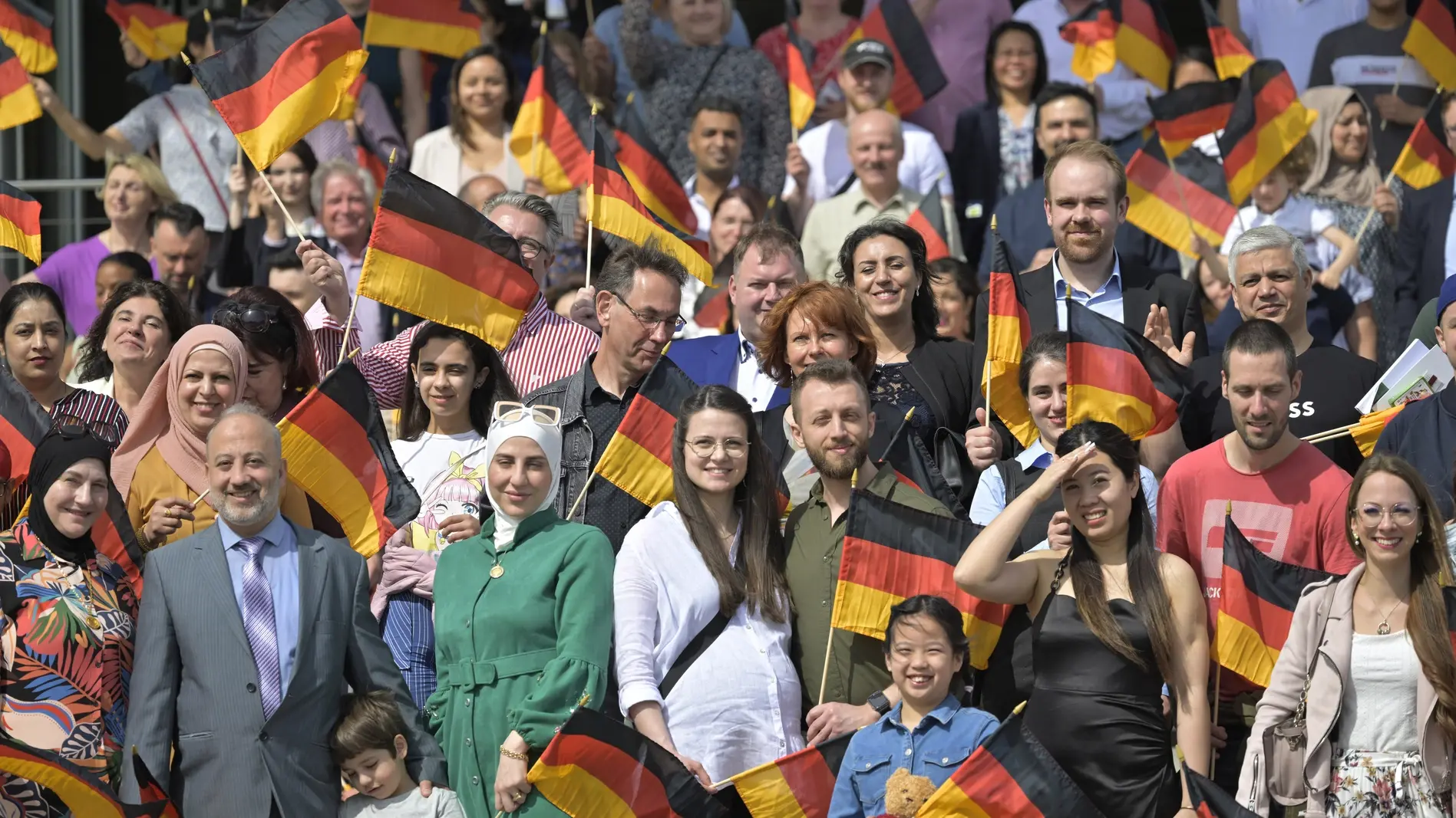 Neu eingebürgerte Personen während eines Gruppenfotos auf dem Landtagsvorplatz