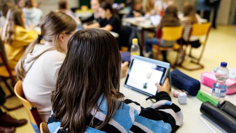 Schülerinnen einer sechsten Klasse arbeiten an ihren Tablets.