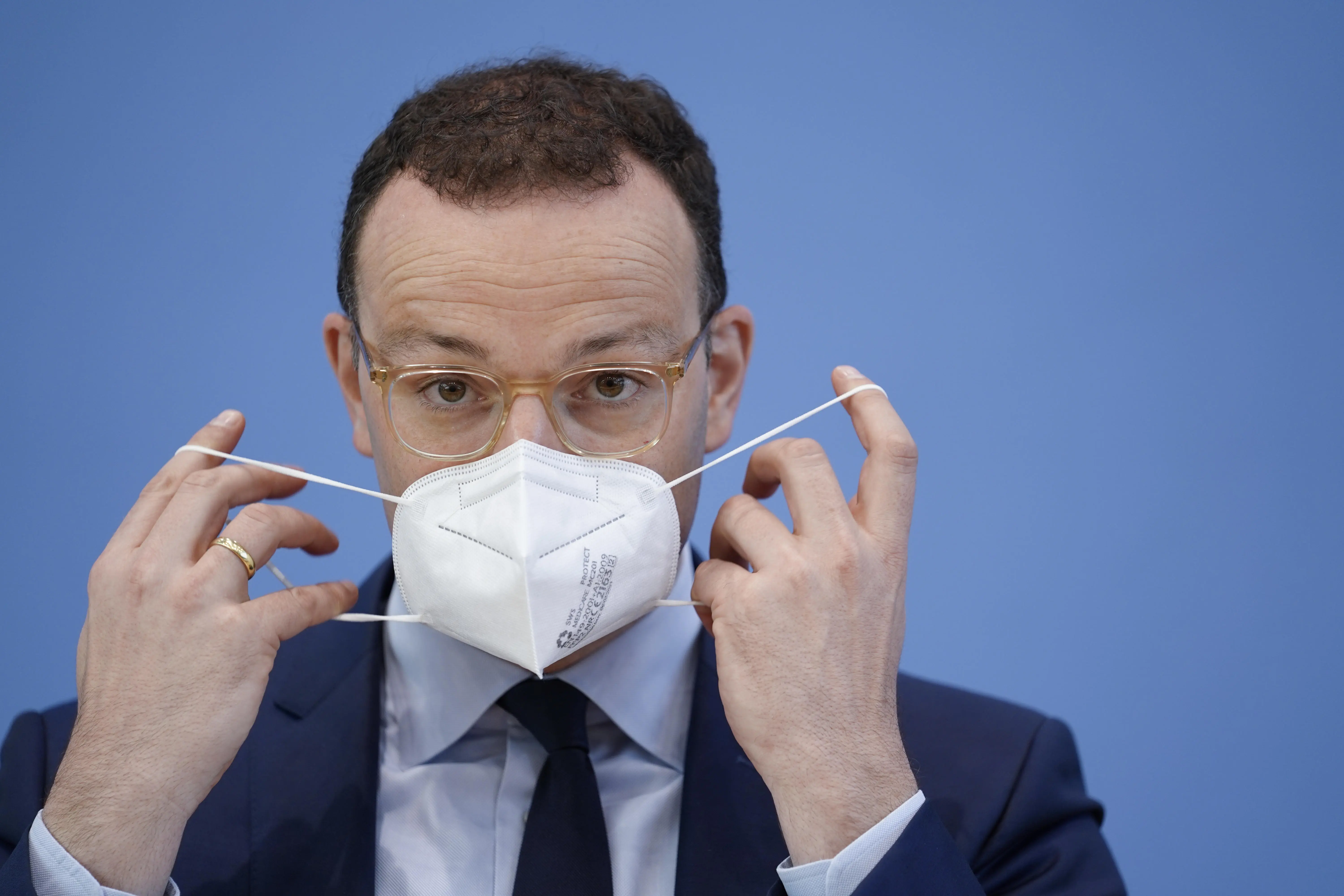 Ex-Bundesgesundheitsminister Jens Spahn beim Anziehen einer FFP2-Maske.