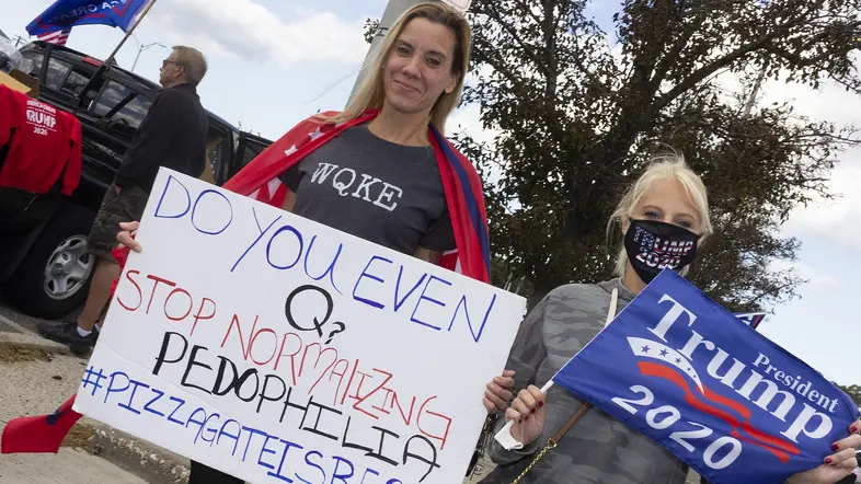 Demonstrantin hält Plakat "Pizzagate is real"