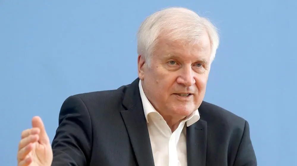 Horst Seehofer vor einer blauen Wand