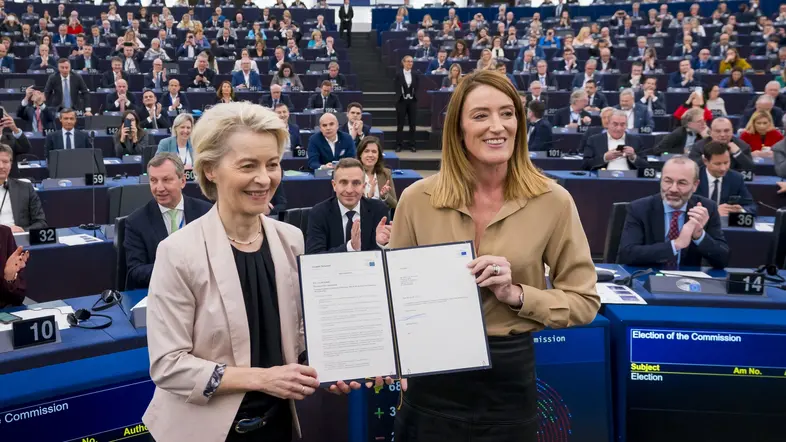 Ursula von der Leyen und Roberta Metsola halten ein Dokument in den Händen