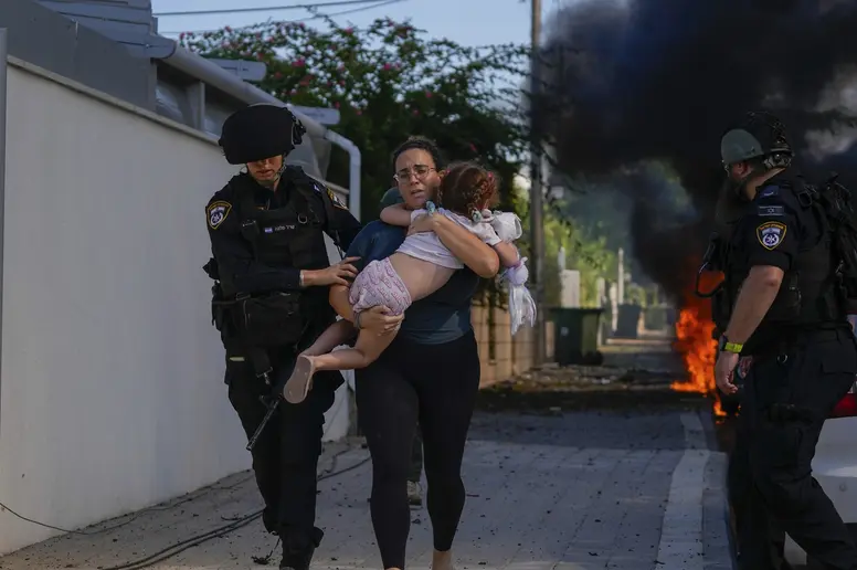 Israelische Polizisten evakuieren eine Frau und ihr Kind