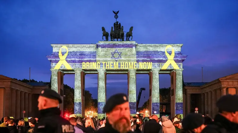 Der Schriftzug "Bring them home now" ist auf dem angestrahlten Brandenburger Tor