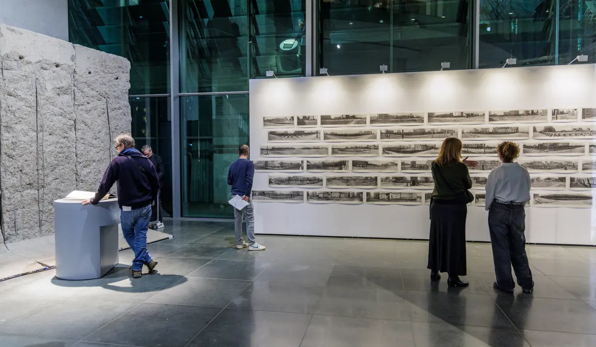 Besucher betrachten Fotografien im Mauer-Mahnmal