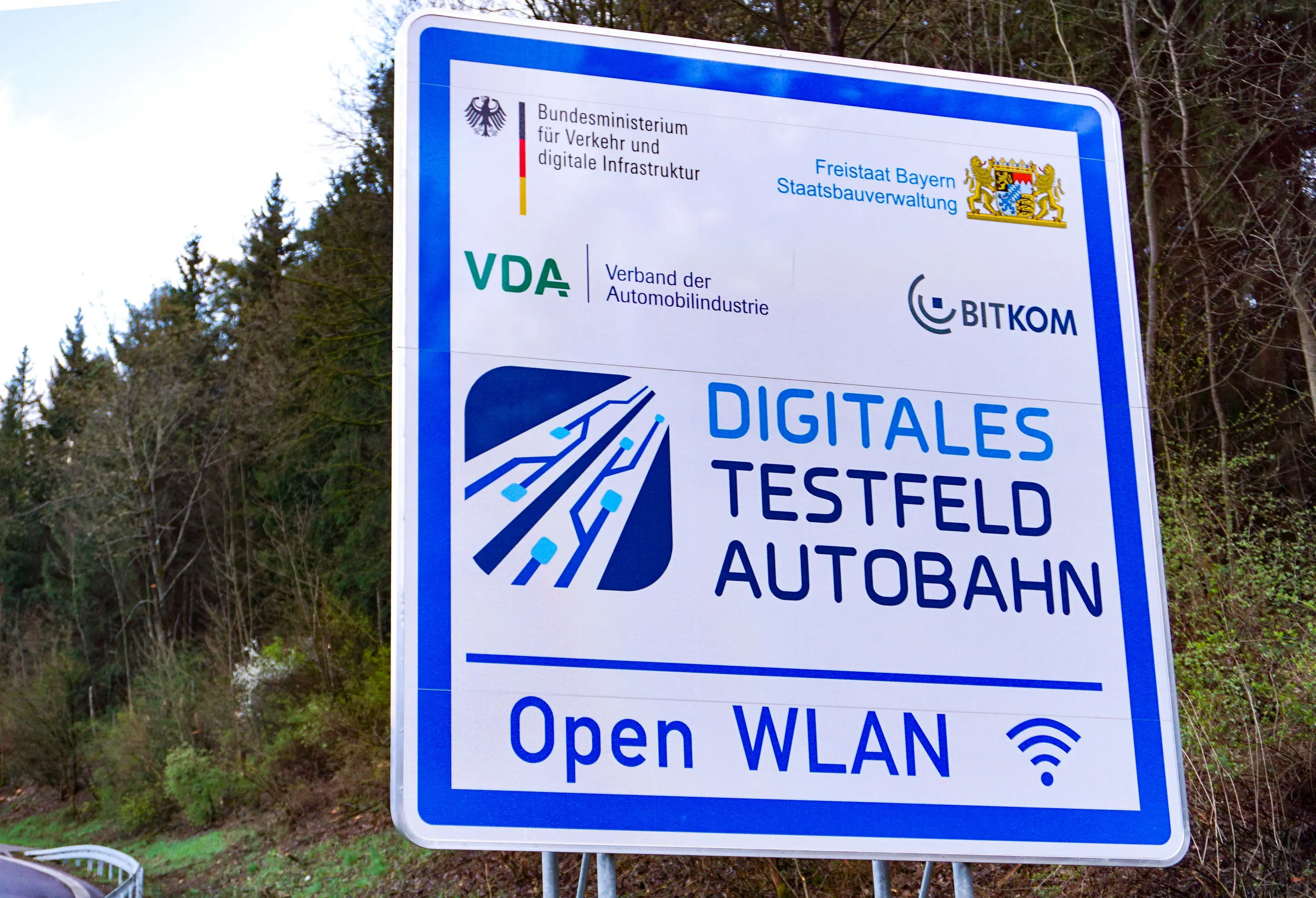Schild weist auf ein digitales Testfeld auf einem Autobahnrastplatz hin
