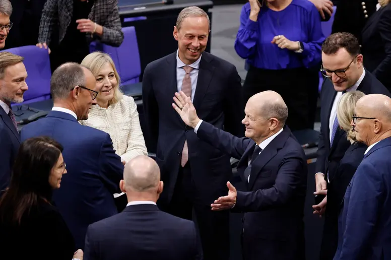 Olaf Scholz, Christian Lindner, Friedrich Merz und weitere lachen im Plenum