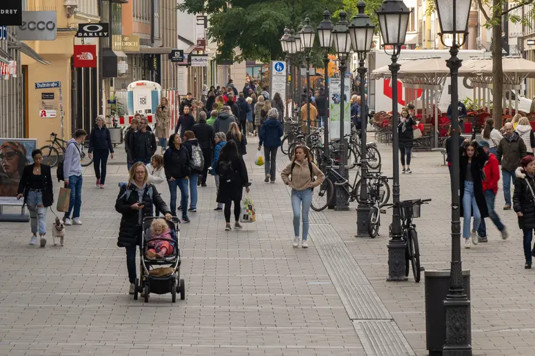 Passanten sind in der Münchner Fußgängerzone unterwegs.