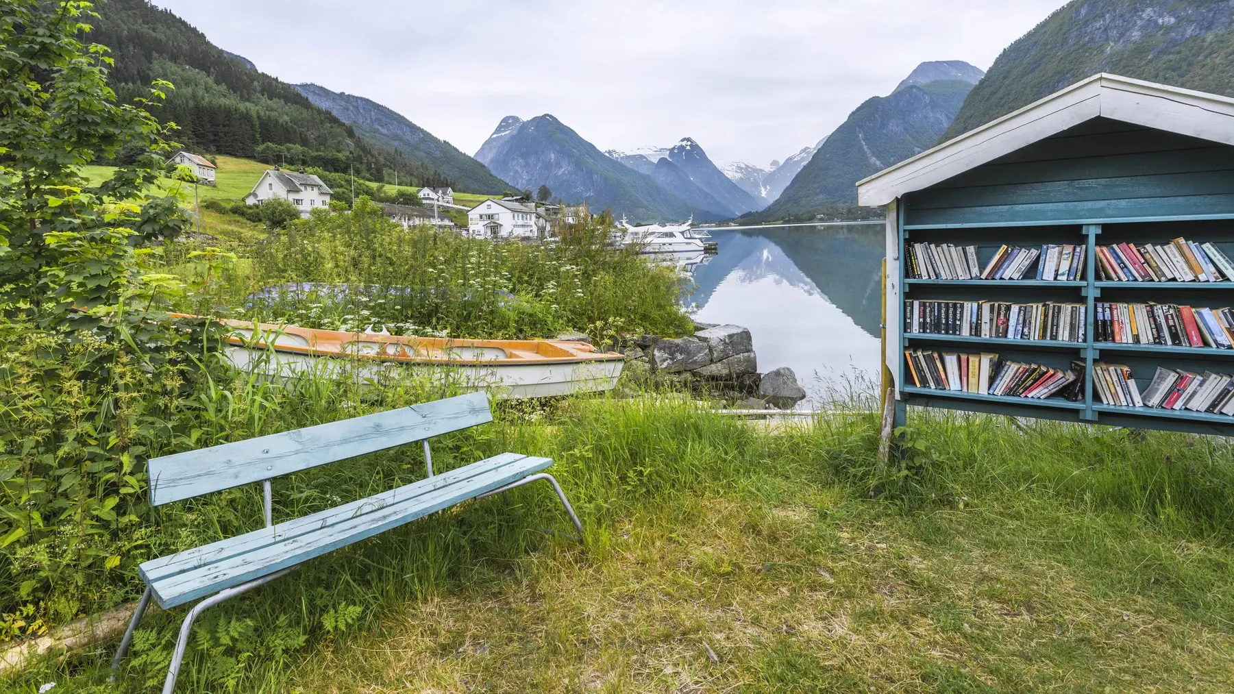 Öffentliches Bücherregal und Bank im Freien am Fjord in Norwegen.