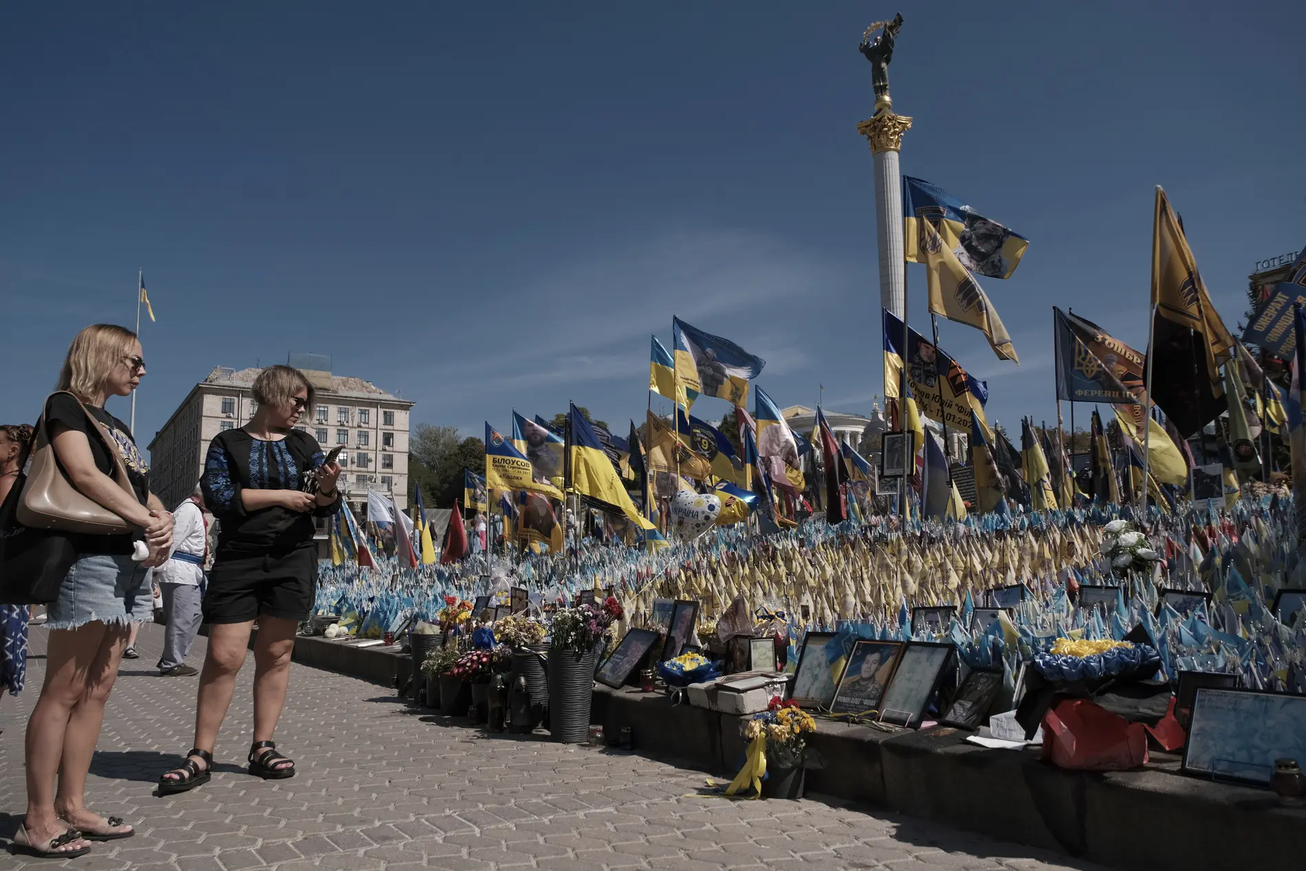 Passanten betrachten Nationalflaggen mit Namen der Gefallenen im Ukrainekrieg.