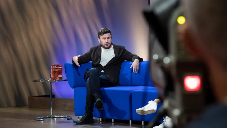 Dmitry Glukhovsky auf einem blauen Sofa auf der Frankfurter Buchmesse 2022