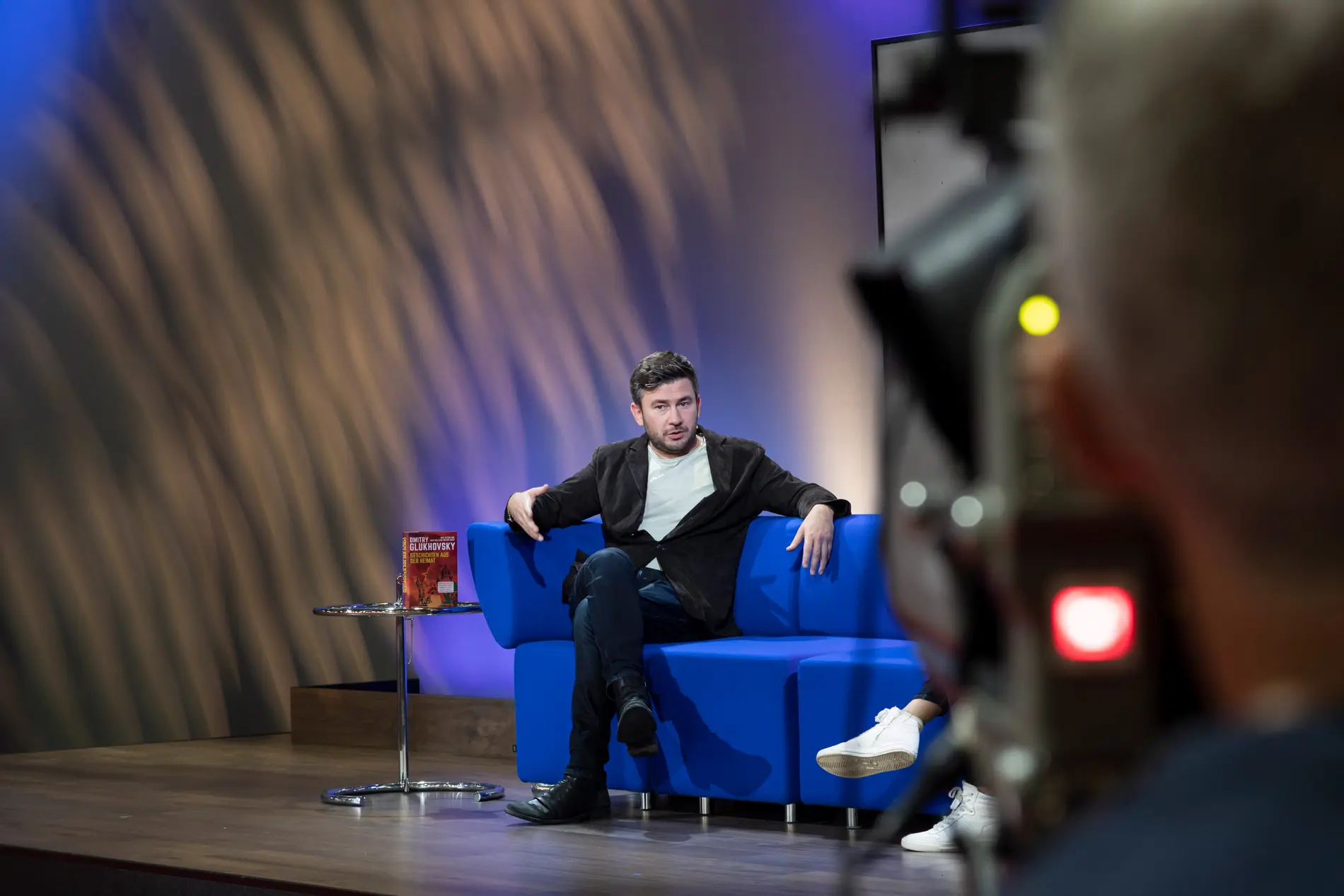 Dmitry Glukhovsky auf einem blauen Sofa auf der Frankfurter Buchmesse 2022