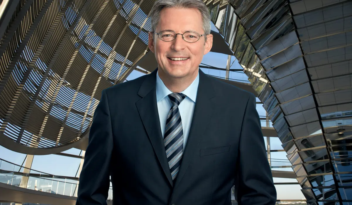 Achim Post im Porträt die Reichstagskuppel im Hintergrund