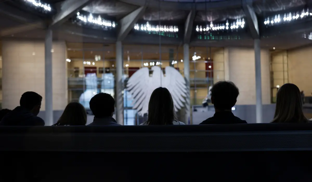 Mehrere Hinterköpfe vor dem Adler im Plenum