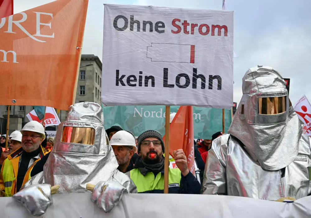 Demonstranten halten ein Plakat mit der Aufschrift „Ohne Strom kein Lohn“.