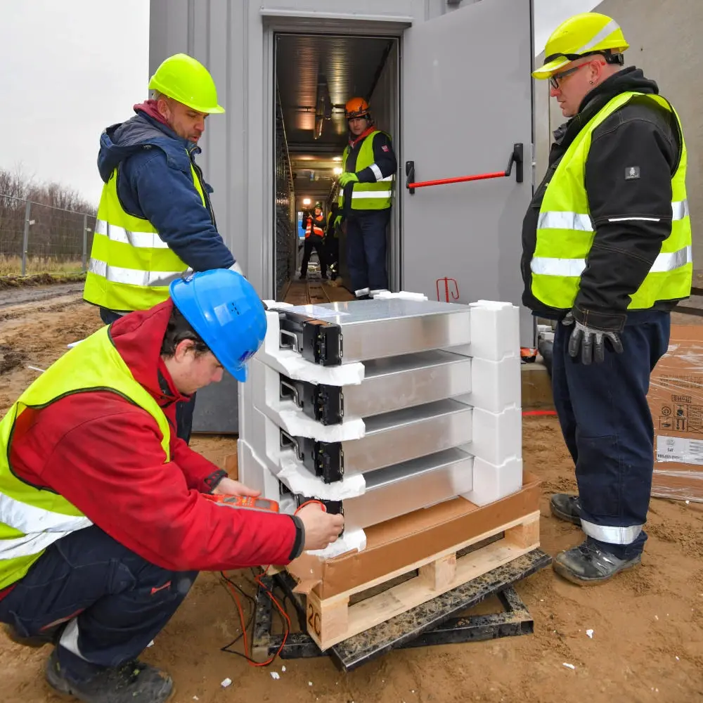 Arbeiter bestücken einen Container mit Lithium-Ionen-Batterien auf der Baustelle
