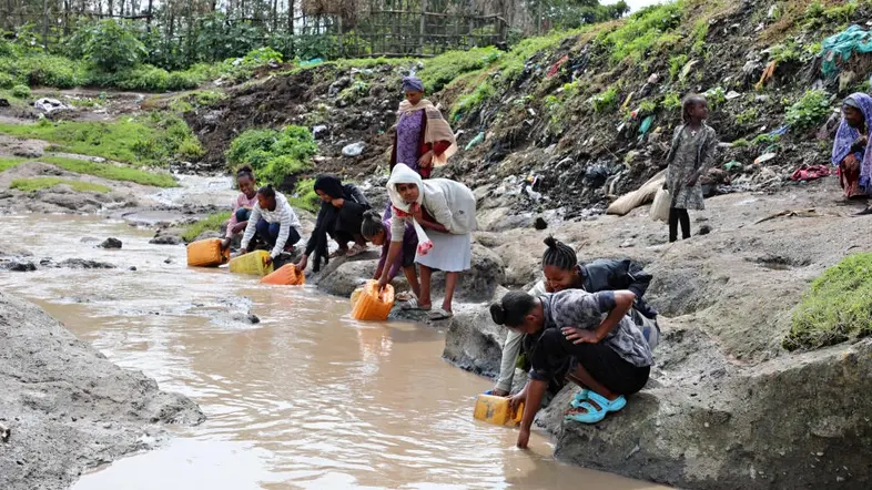 Mehrere Frauen füllen Eimer mit Wasser an einem Fluss in Äthiopien