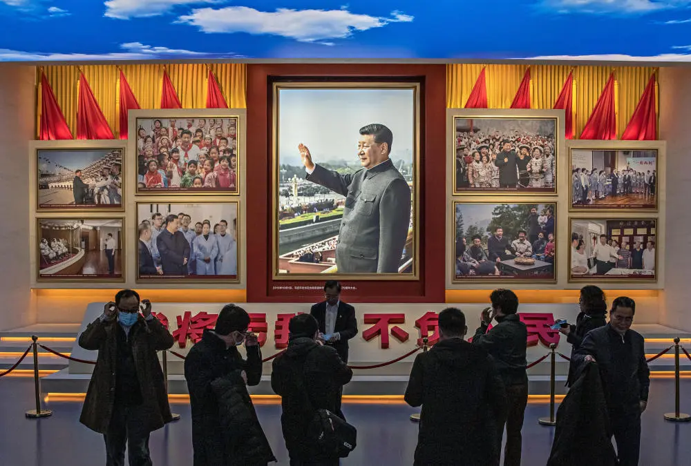 Besucher des Museums der Kommunistischen Partei Chinas in Peking vor einem Porträt von Staatspräsident Xi Jinping