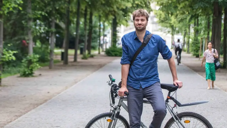 Stefan Gelbhaar lehnt an einem Fahrrad.
