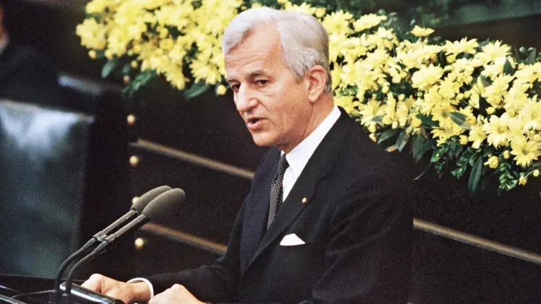 Richard von Weizsäcker am Rednerpult vor gelben Blumen