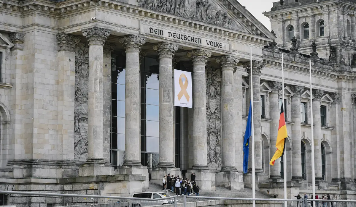 Mit einem gelben Schleifenbanner und Trauerbeflaggung gedenkt der Bundestag