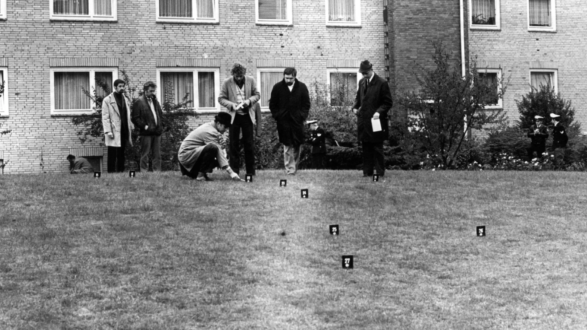Schwarz-Weiß-Foto von Kriminalbeamten bei der Spurensicherung