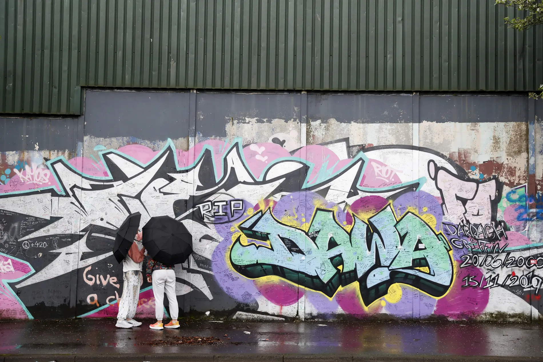 Touristen an "Friedensmauern" mit Graffiti in Belfast