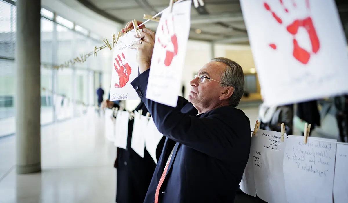 Paul Lehrieder hängt ein Blatt Papier auf