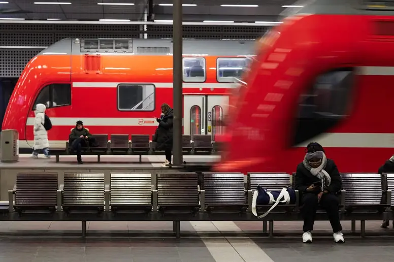 Reisende warten im Hauptbahnhof auf ihre Züge