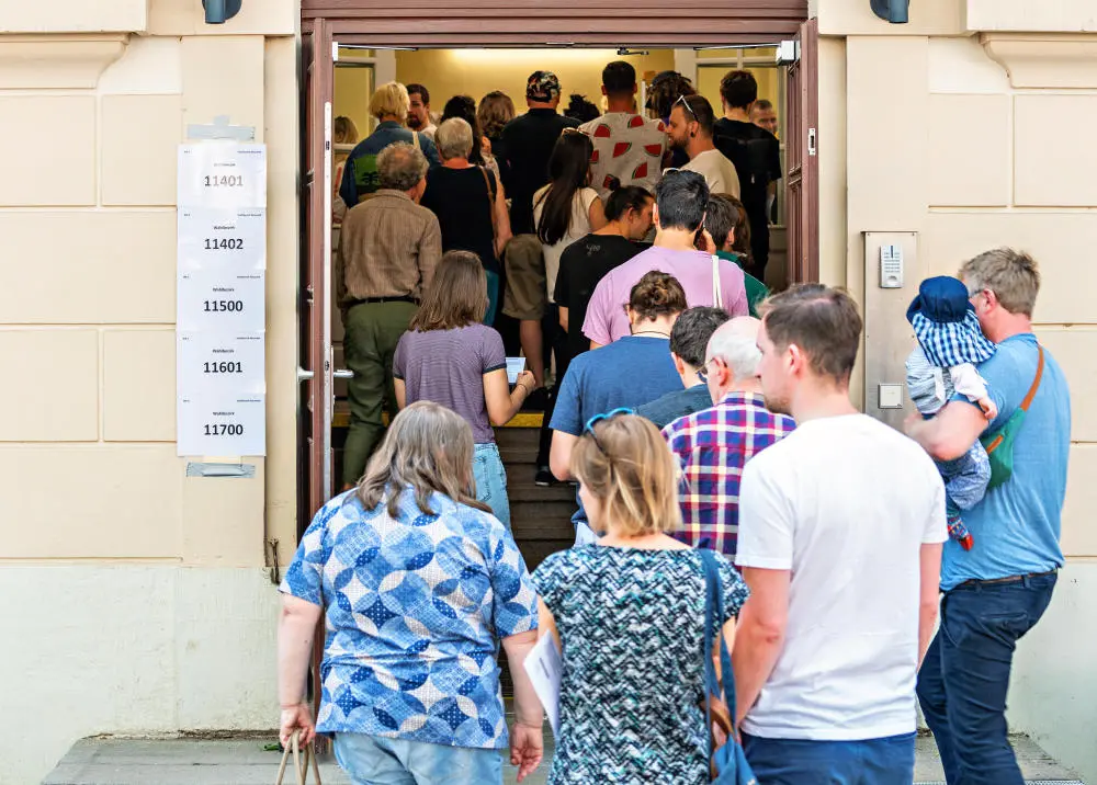 Wähler stehen vor der Stimmabgabe in Sachsen vor einem Wahllokal an